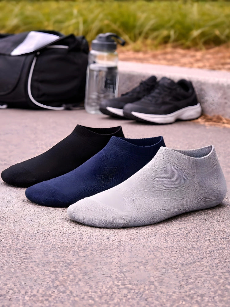Three pairs of ankle socks in black, blue, and gray on a concrete surface with a water bottle and bag in the background.

Active Star Men's Trainer Socks Black, Navy, Grey