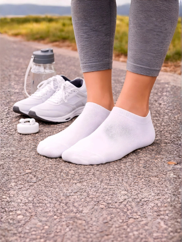 White athletic shoes and socks on a road with a water bottle and white object nearby.

Ladies white trainer socks by Stylewar