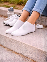 White socks worn with white sneakers on a concrete surface.

White ladies trainer socks for casual wear and active styling by Stylewar