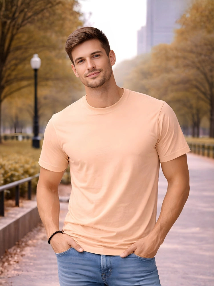Man wearing a peach t-shirt and blue jeans standing in an urban park setting.

Men’s light peach crew neck half sleeve T-shirt by Stylewar