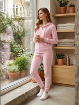 Woman in pink tracksuit standing by a window holding a cup, with plants and shelves in the background.

Ladies' baby pink zip-up hoodie and jogger tracksuit set by Stylewar
