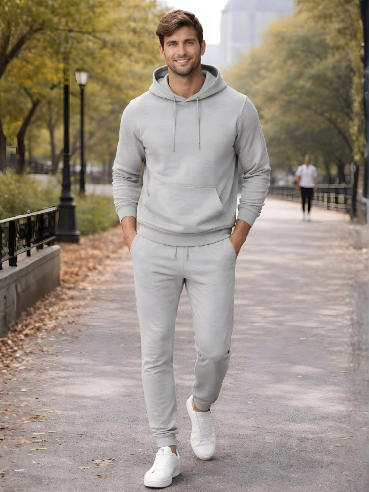 Man wearing a light gray hoodie and pants walking on a path with trees and people in the background.

Men’s grey melange pullover hoodie and jogger tracksuit set by Stylewar