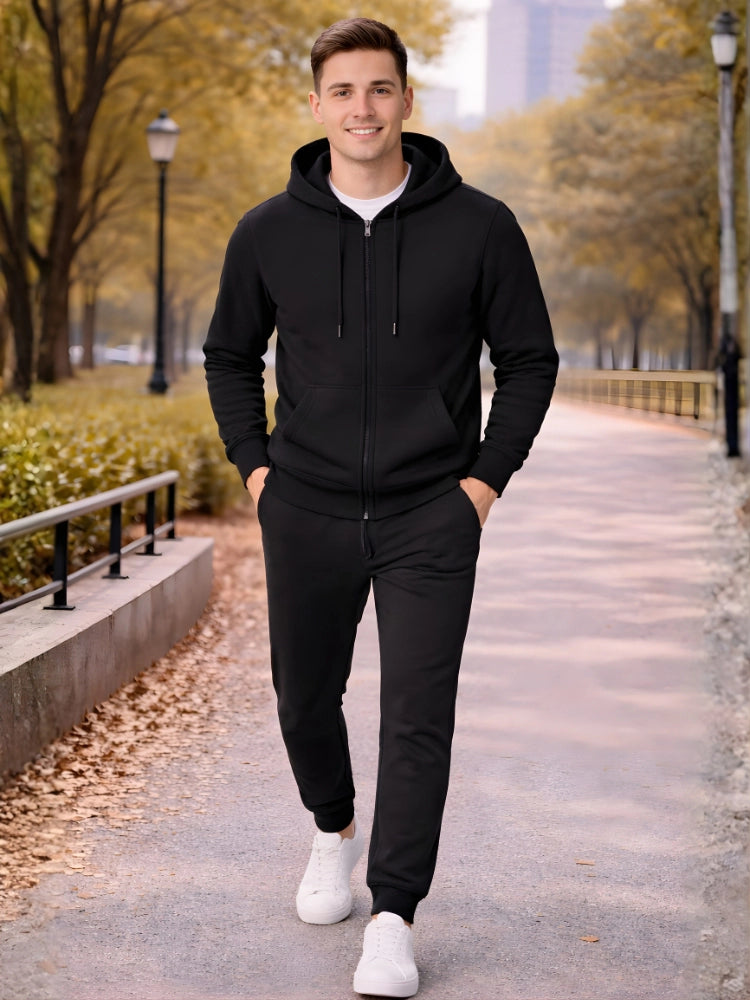 Man wearing a black hoodie and pants with white sneakers standing on a path with trees and buildings in the background. 

Black men’s zip hoodie with matching jogger trousers by Stylewar