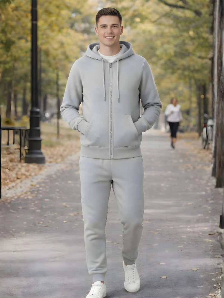 Man wearing a gray tracksuit standing on a path in a park.

Grey melange men’s zip hoodie with matching jogger trousers by Stylewar