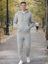 Man wearing a gray tracksuit standing on a path in a park.

Grey melange men’s zip hoodie with matching jogger trousers by Stylewar