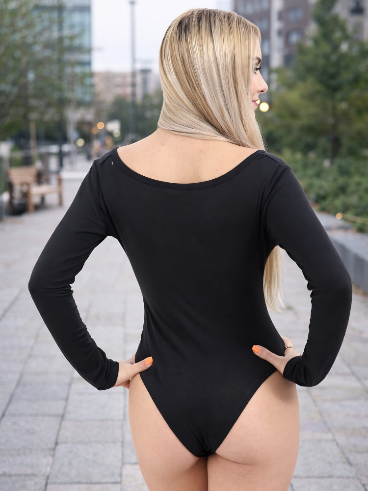 Person wearing a black bodysuit with long sleeves in an outdoor setting. Womens Round Neck Long Sleeve Viscose Leotard