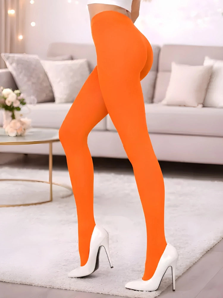 Person wearing bright orange leggings and white high heels in a living room setting. Adult Crazy Chick Opaque Orange Tights