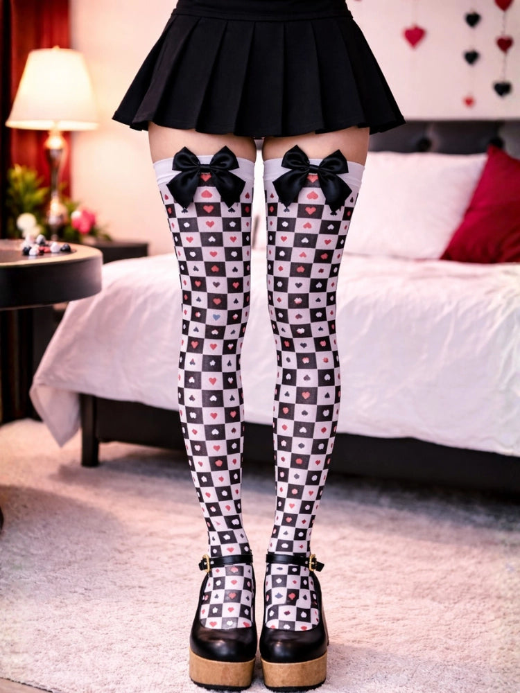 Person wearing checkered tights with bows and a black pleated skirt in a bedroom setting. Women’s Queen of Hearts Thigh High Stockings With Bow
