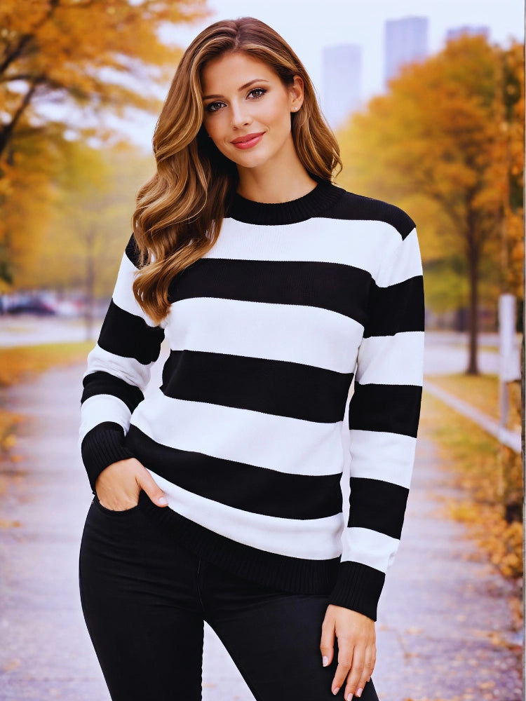 Woman wearing a black and white striped sweater in an autumn setting. Womens Black & White Stripe Knitted Jumper