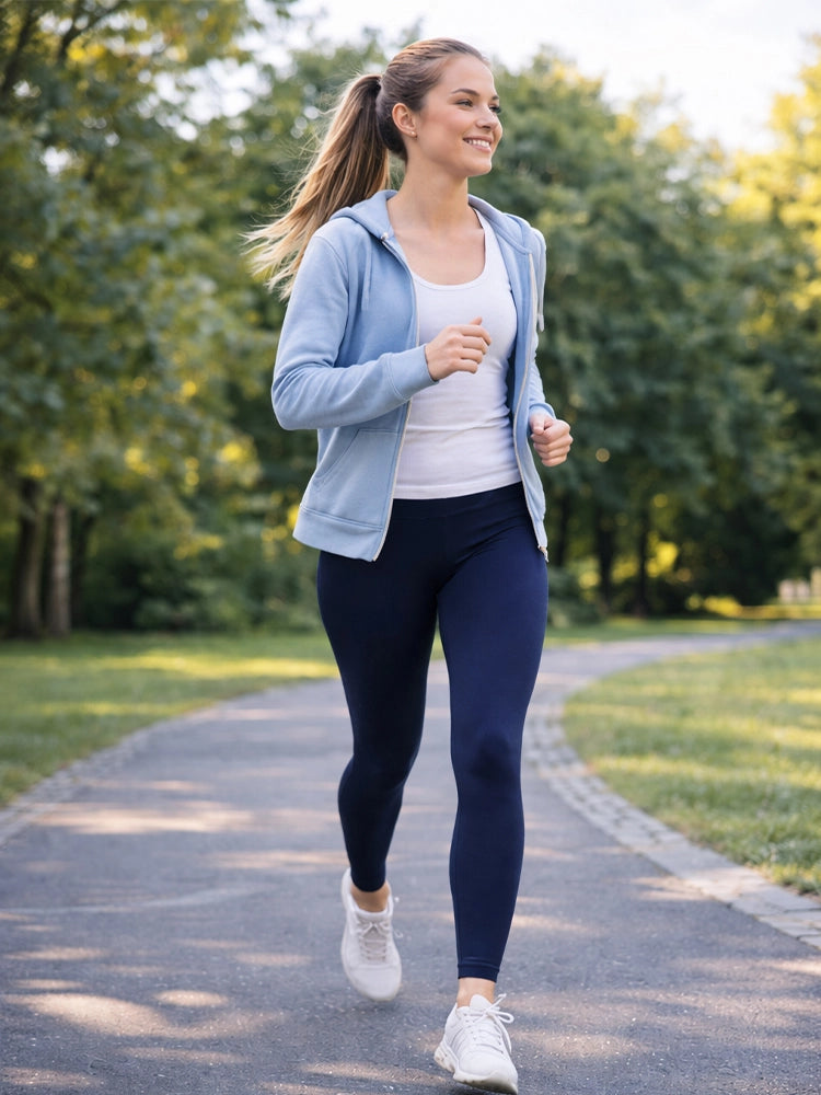 Woman in athletic wear walking on a path in a park